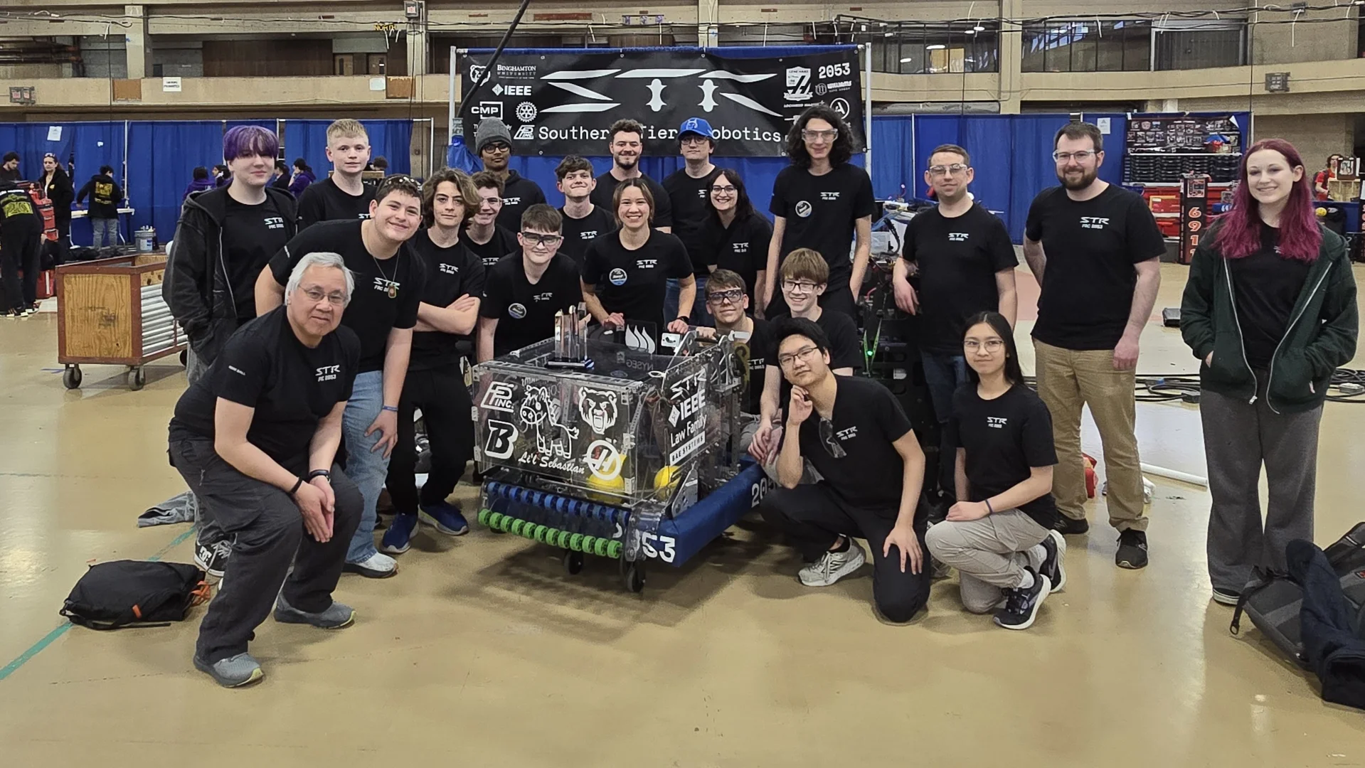 The team standing together with the robot after competition