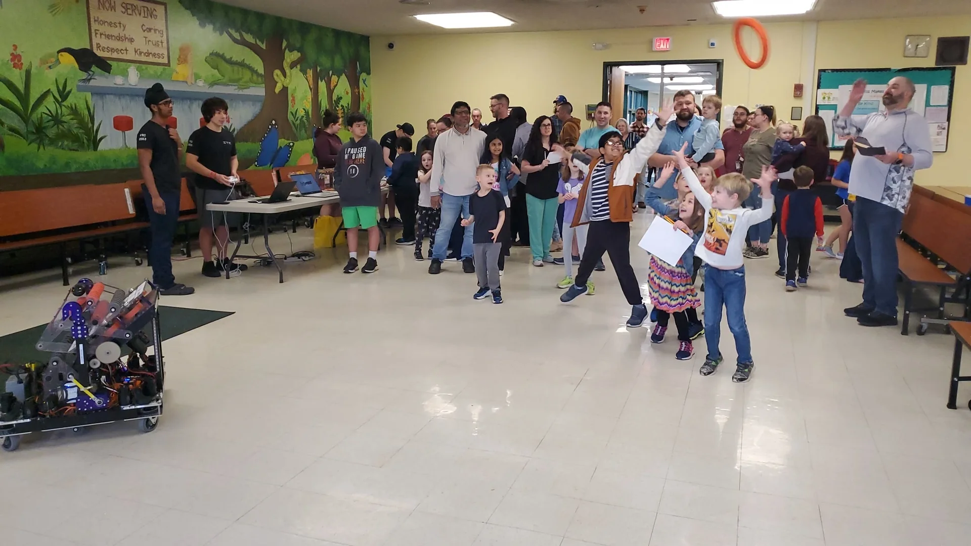 Elementary students running to meet the robot at an outreach event