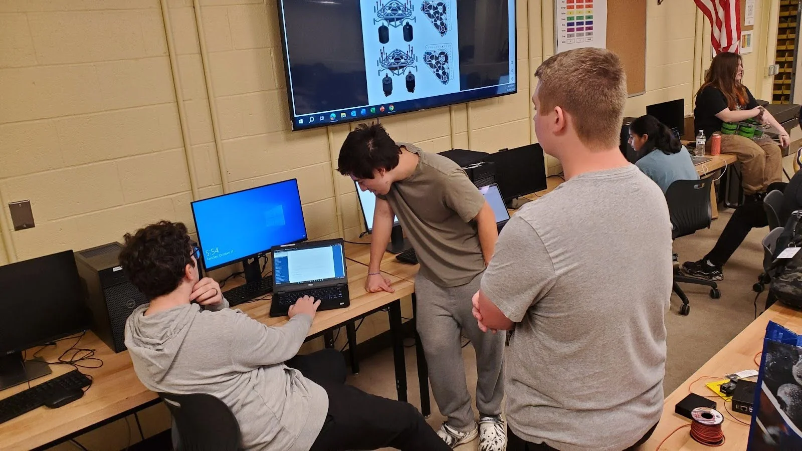 Team members at a laptop, discussing the software plan